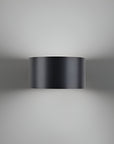 Black cylindrical wall rechargeable light fixture on a gray background