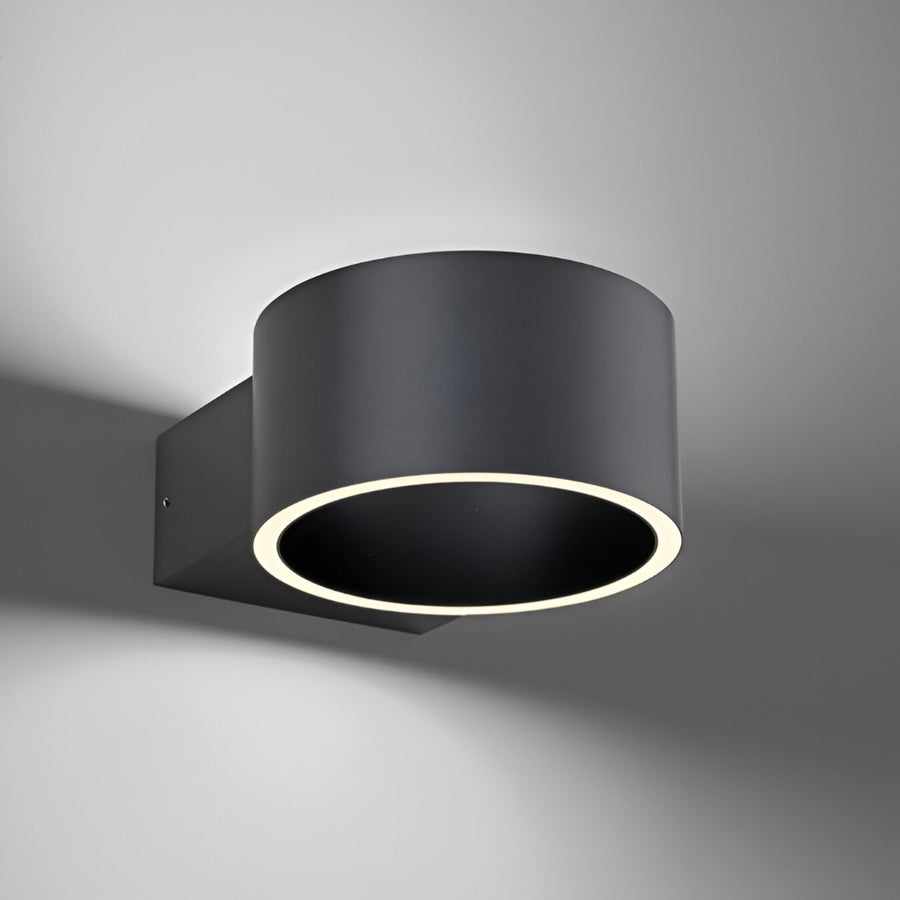 Black cylindrical wall light fixture on a gray background