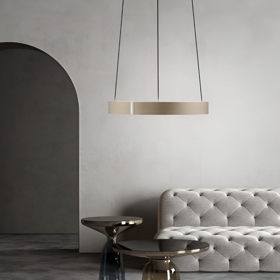 Modern interior with a gray tufted sofa and pendant kinetic light against a neutral wall.