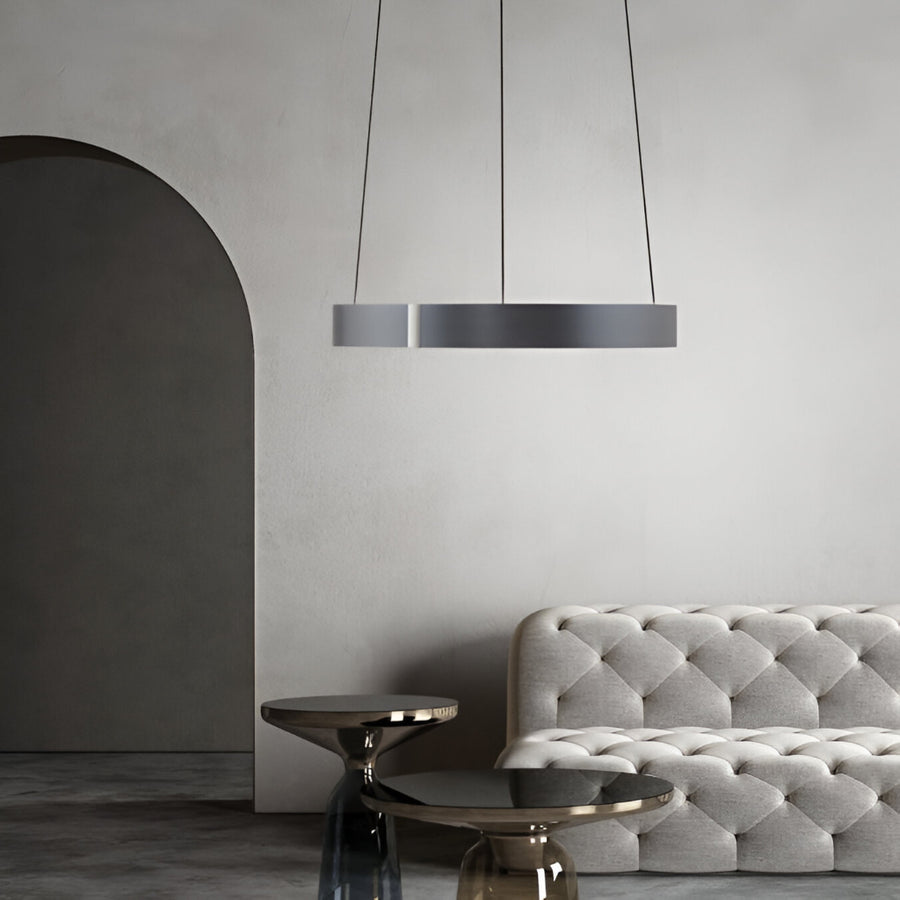 Modern interior with a gray tufted sofa and kinetic chandelier.