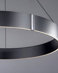 Modern kinetic pendant light with black and silver design on a gray background