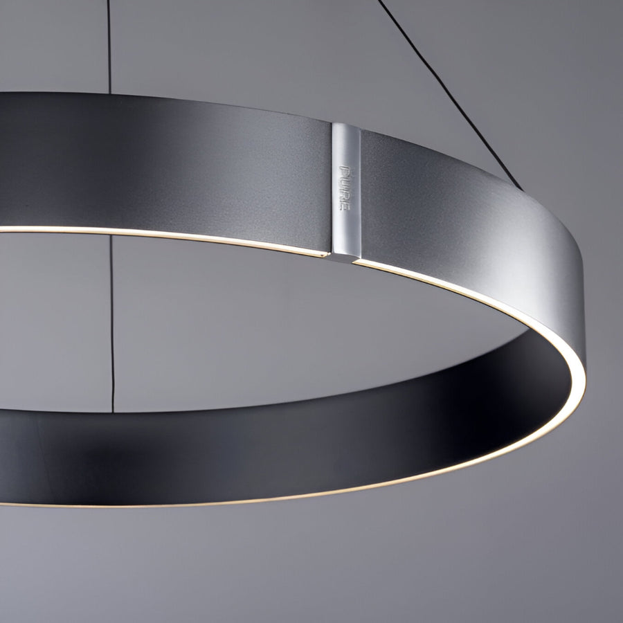 Modern kinetic pendant light with black and silver design on a gray background