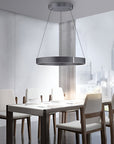 Modern dining room with a kinetic chandelier, table, and chairs.