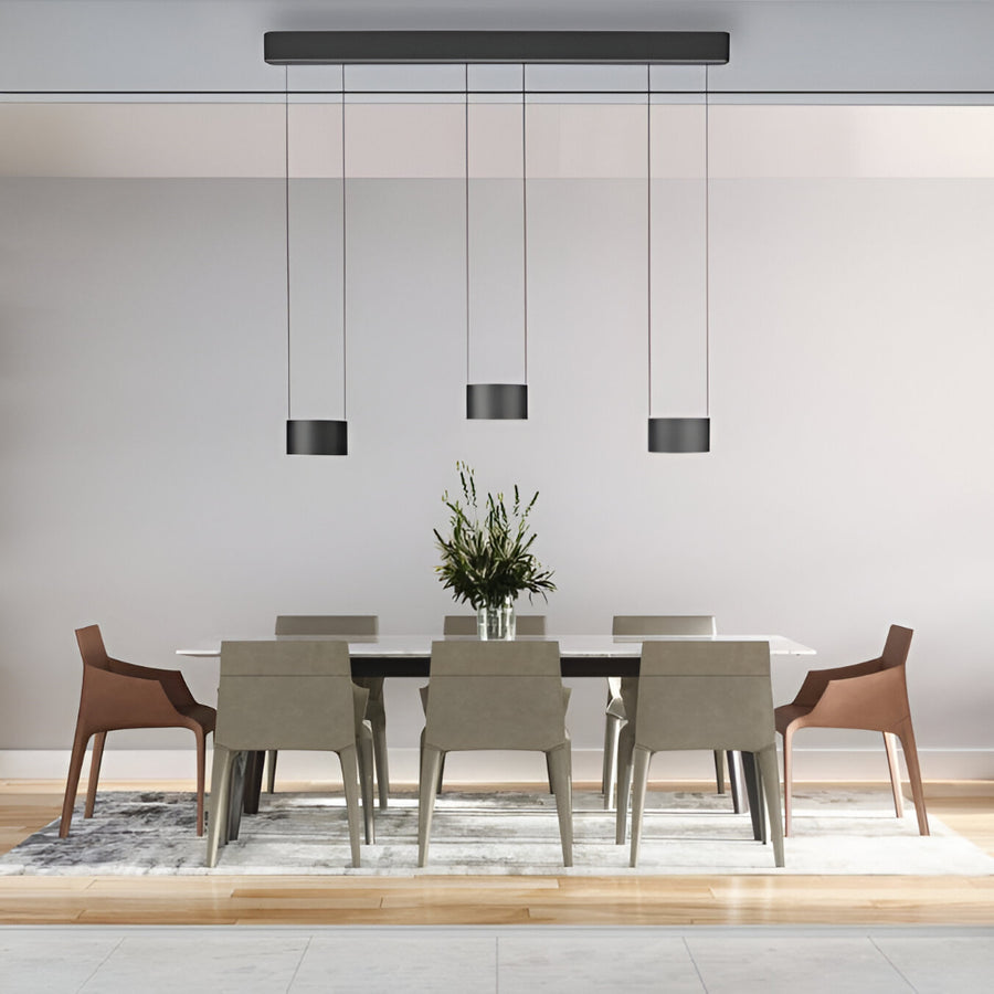 Modern dining room with a table and chairs under height adjustable chandeliers. 