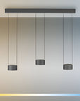 Modern pendant light fixture with three hanging cylindrical shades against a gradient background