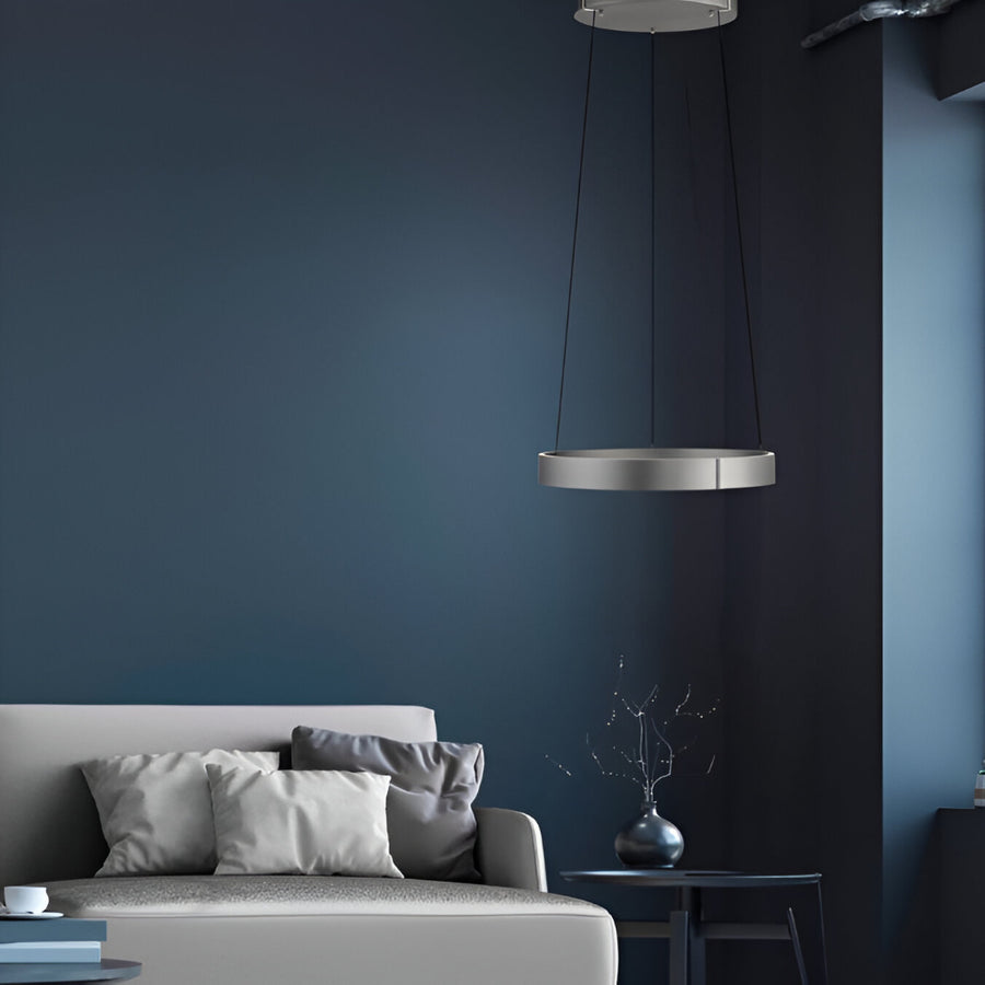 Modern living room with a dark blue wall, gray sofa, and pendant kinetic light.