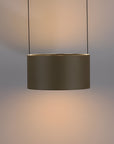 Modern pendant light with a cylindrical shade on a neutral background