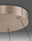 Kinetic ceiling light fixture with beige finish on a dark gray background