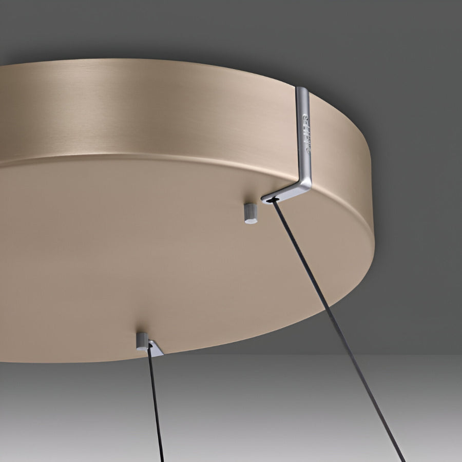 Kinetic ceiling light fixture with beige finish on a dark gray background
