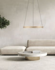 Modern living room with a beige sofa, round coffee table, and hanging kinetic light fixture available at Spacio retail store in Mumbai. 