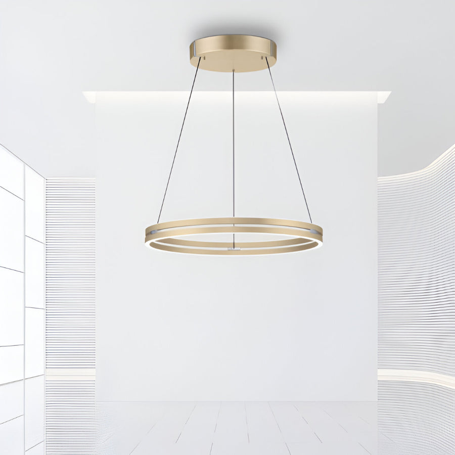Gold pendant kinetic light fixture hanging in a modern interior setting