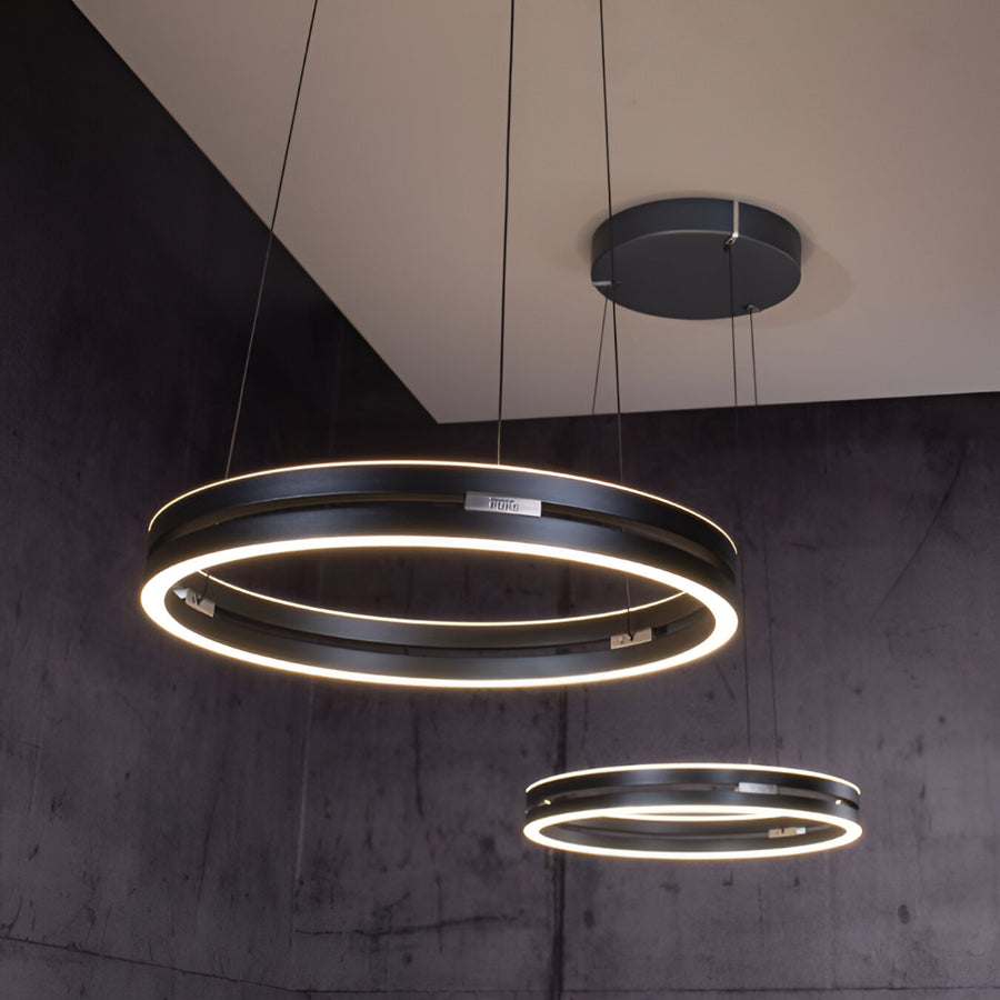 Modern kinetic pendant lights with circular design hanging from the ceiling.