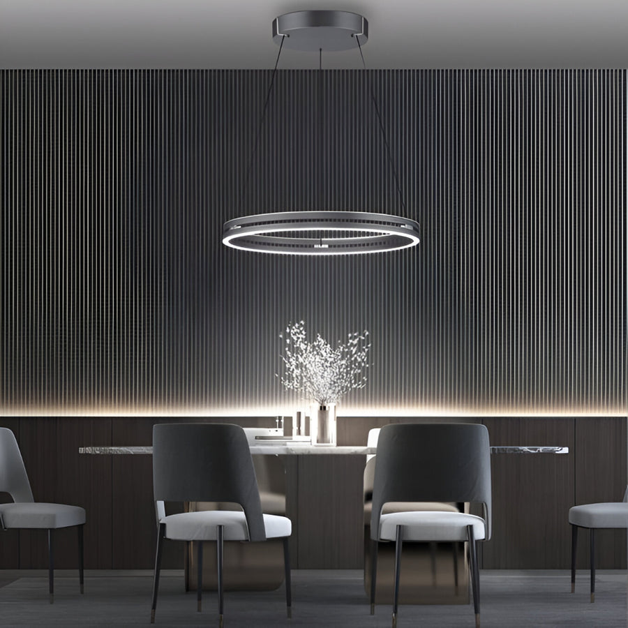 Modern dining room with a kinetic chandelier, table, and chairs against a dark wall.