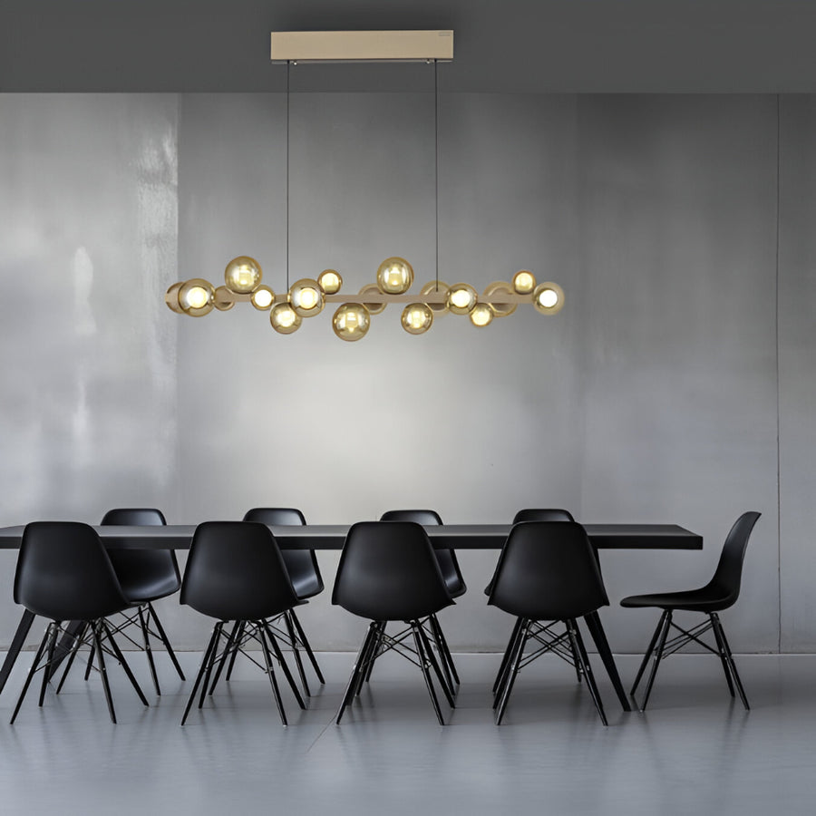 Modern dining room with a long table and black chairs, featuring a stylish kinetic pendant light.