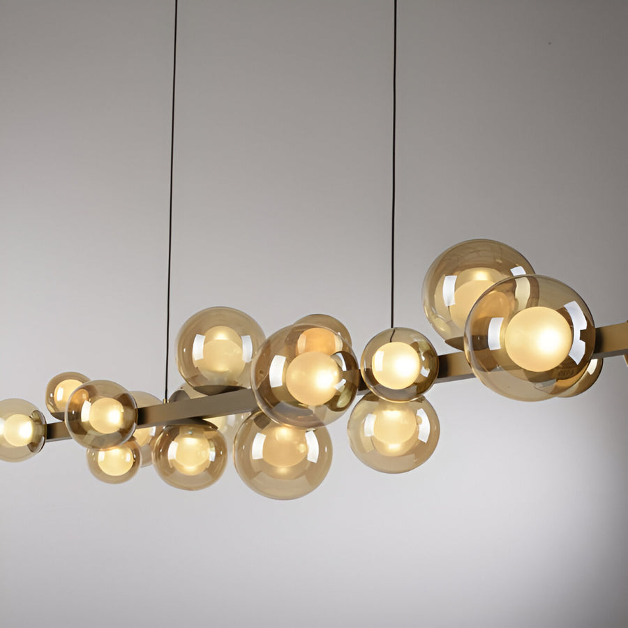 Modern kinetic chandelier with gold finish and glass shades on a neutral background