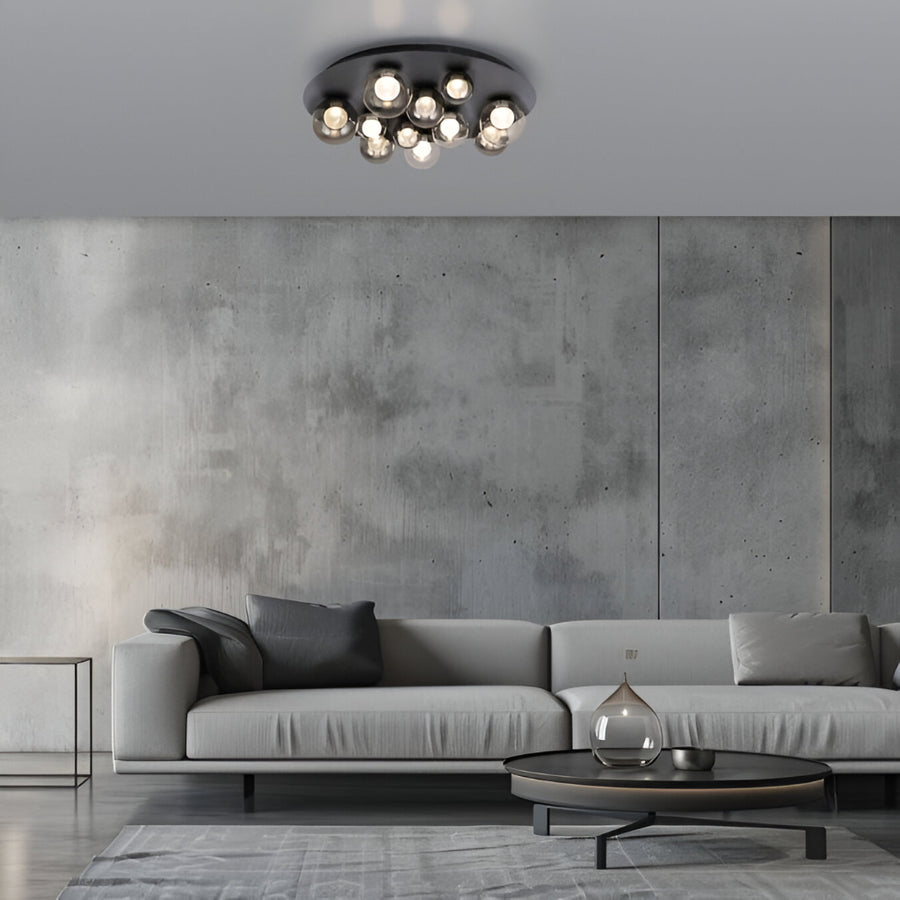 Modern living room with a gray sofa, round coffee table, and ceiling light fixture.