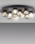 Ceiling light fixture with multiple glass bulbs on a plain background