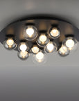 Modern ceiling light fixture with multiple glass bulbs on a gray background
