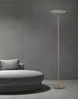 Modern floor lamp next to a gray sofa against a gray wall
