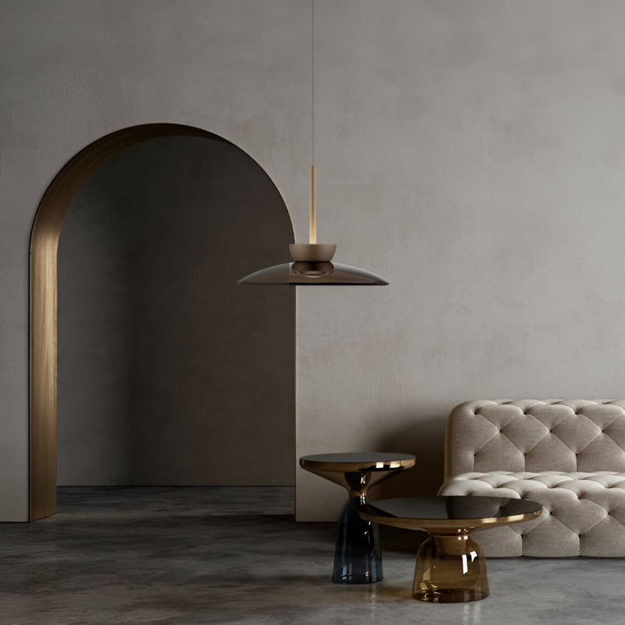 Modern interior with a gray sofa, stylish lamp, and archway.