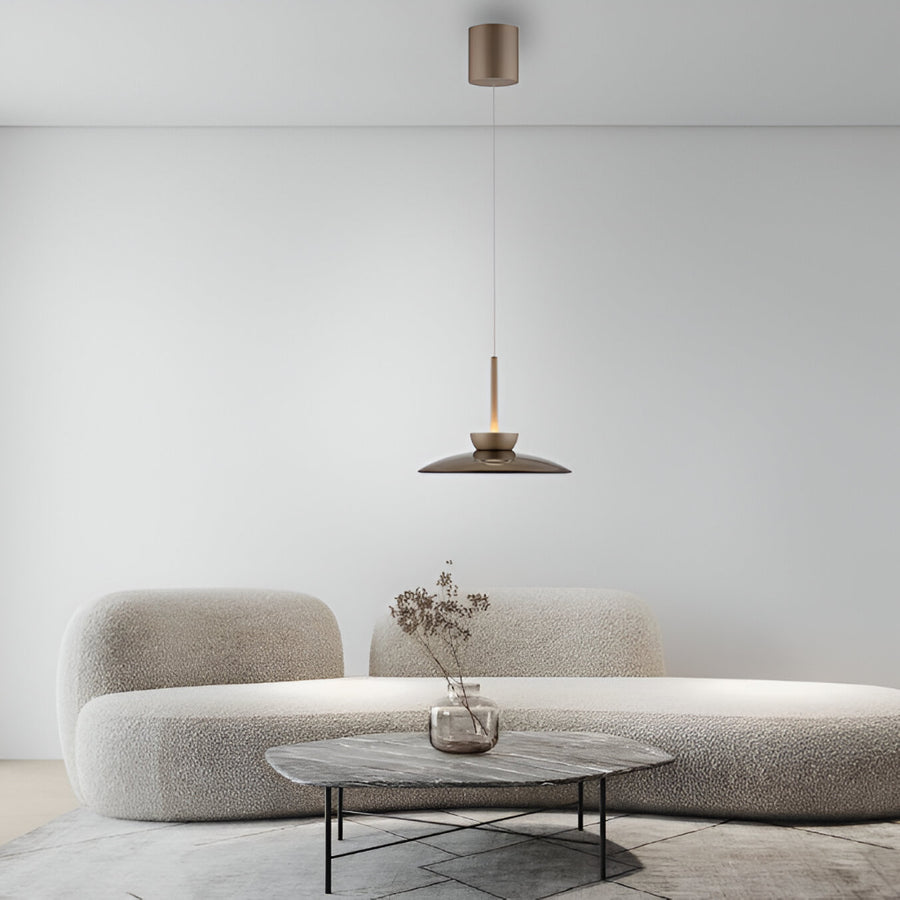 Modern living room with a textured sofa, small table, and pendant light.