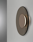 Modern wall light fixture with smoked glass cover on a gray background