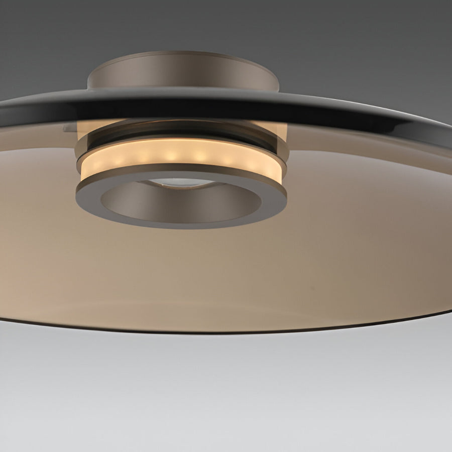Close-up of a modern ceiling light fixture with metallic finish on a neutral background