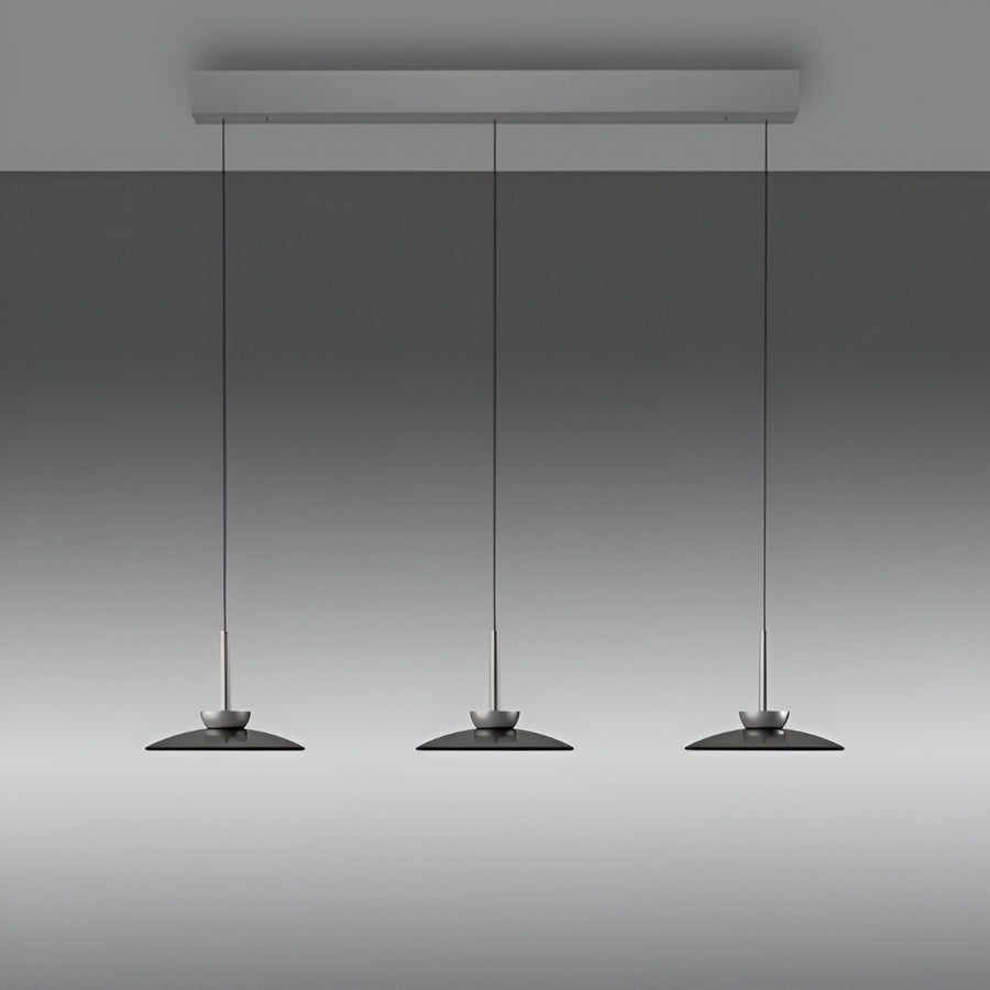 Three pendant kinetic lights hanging from a ceiling fixture against a gray background