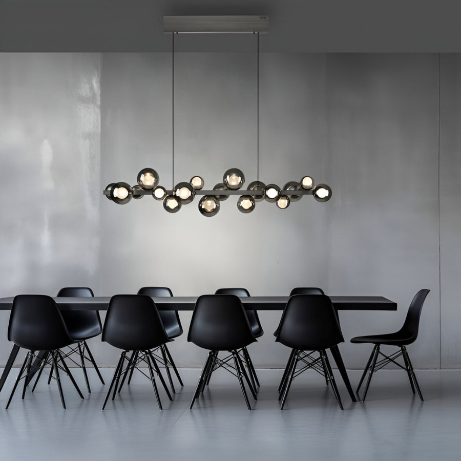 Modern dining room with black chairs and a long, stylish kinetic chandelier.