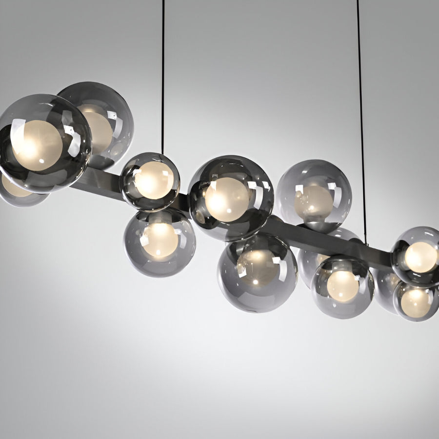 Modern kinetic chandelier with glass globe lights on a neutral background