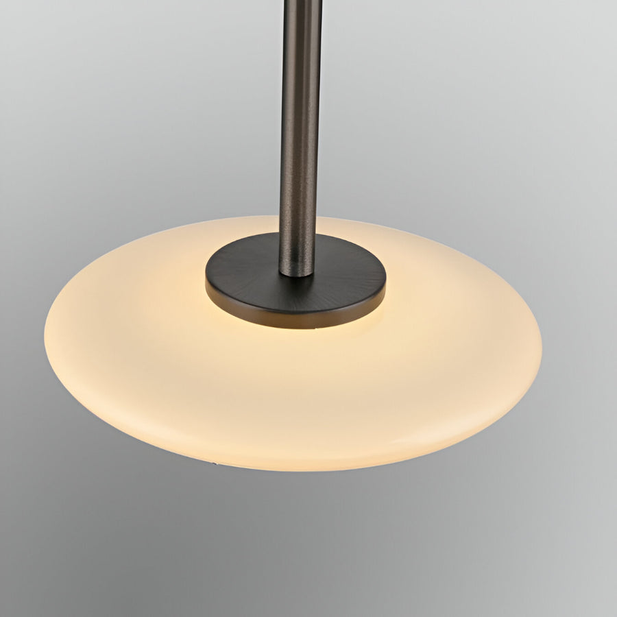 Modern pendant light with black fixture and glass shade on a gray background
