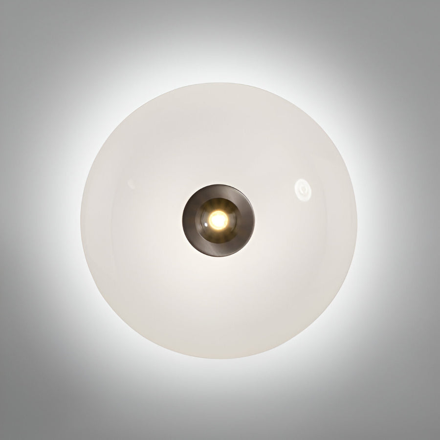Round wall light fixture with a white glass cover on a gray background