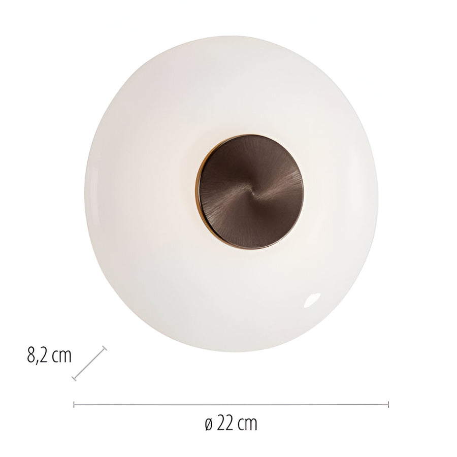 Round white object with bronze center and measurements on a white background