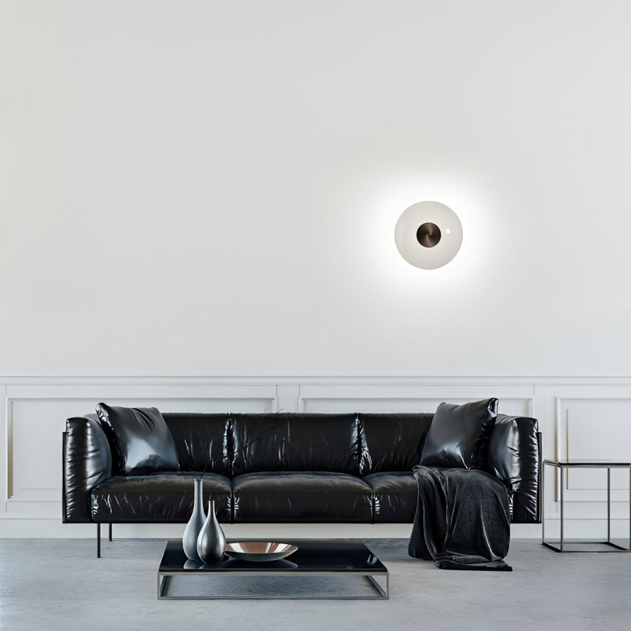 Modern living room with a black leather sofa and decorative items.