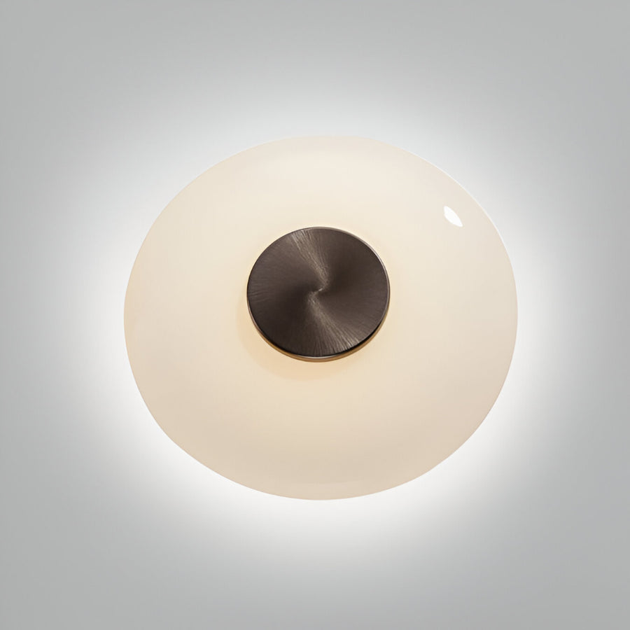 Round wall light fixture with a metallic top and glass cover on a gray background