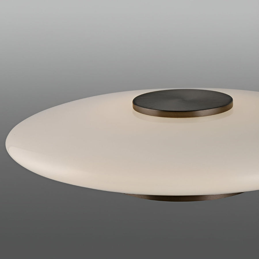 Modern table lamp fixture with a white shade and bronze base on a gray background