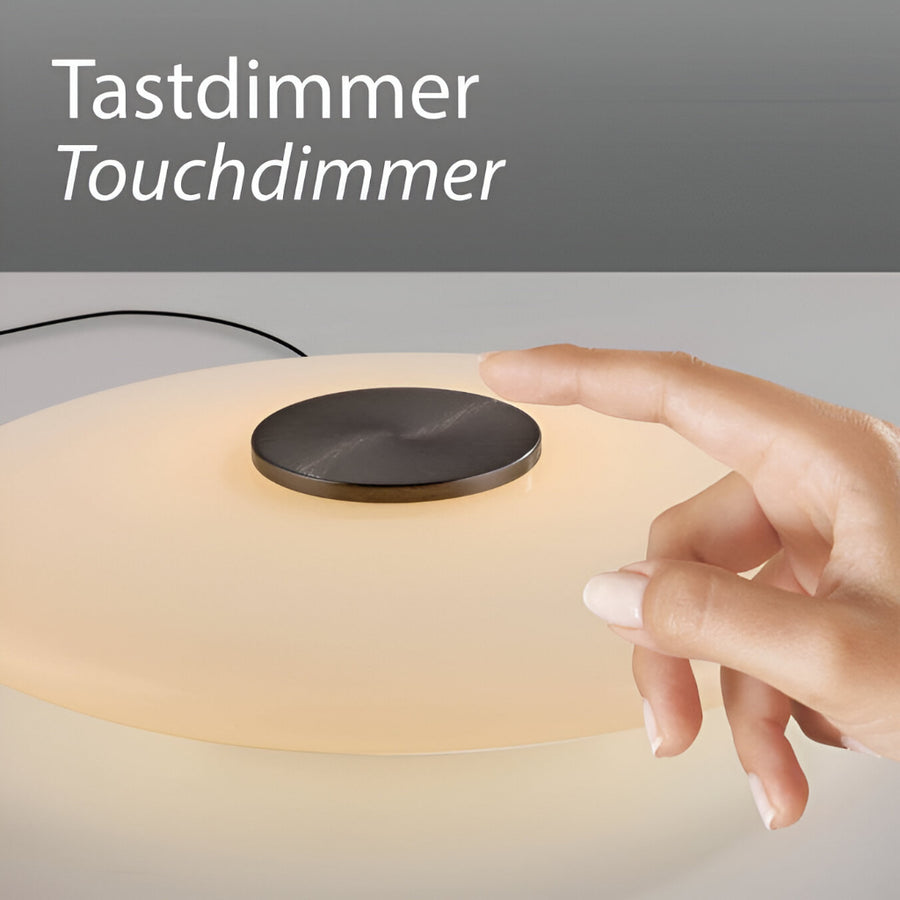 Hand touching a touch dimmer switch on a lamp with 'Tastdimmer Touchdimmer' text above.