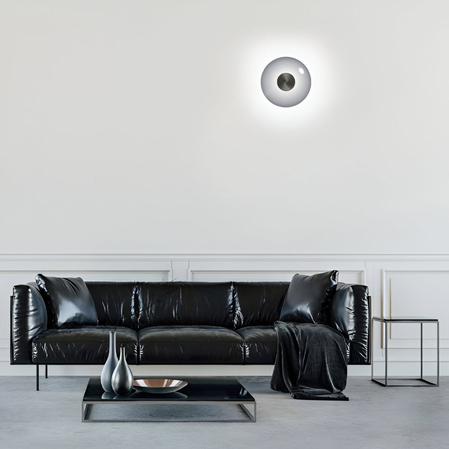 Modern living room with a black leather sofa and decorative items.