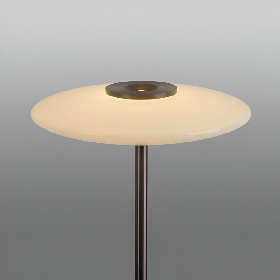 Floor lamp with a round white shade and metallic base on a gray background