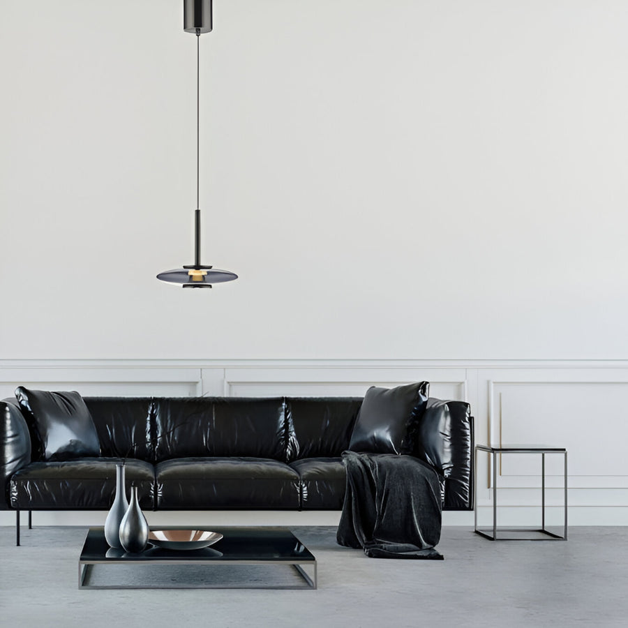 Modern living room with a black leather sofa, coffee table, and a manual lift pendant light.