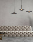 Beige tufted sofa in a modern living room with pendant lights and a neutral color palette.