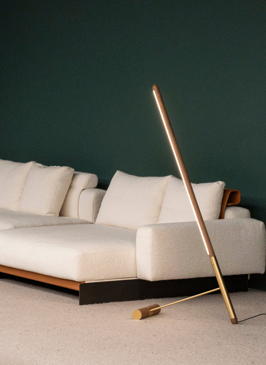 Modern living room with a beige sectional sofa and a tall, thin floor lamp.