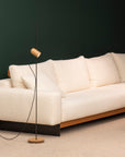 Beige sofa with a modern floor lamp against a dark wall