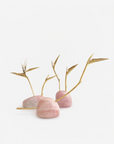 Decorative arrangement with pink quartz and gold branches of half and full bloom bird of paradise flowers on a white background