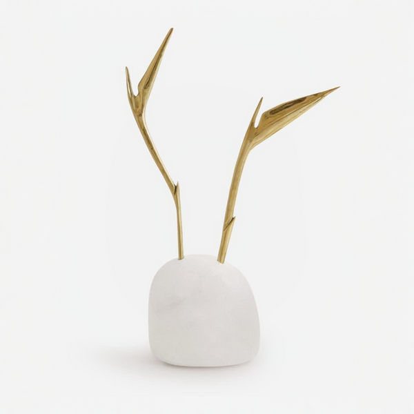 Small white quartz sculpture with gold bird of paradise flower on a white background