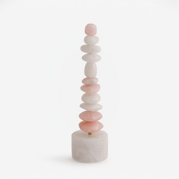 A table top totem sculpture made of stacked mixed colour quartz  on a white background
