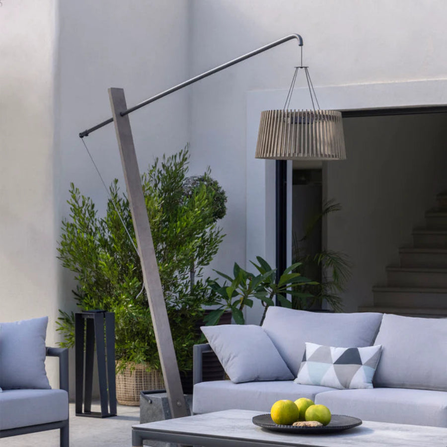 Modern outdoor living space with a sofa, chairs, and a solar floor lamp by Les Jardins available at Spacio retail stores in Mumbia & Kolkata. 