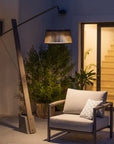 Modern outdoor chair with a solar floor lamp and plants in a garden setting by Les Jardins available at Spacio retail stores in Mumbia & Kolkata. 