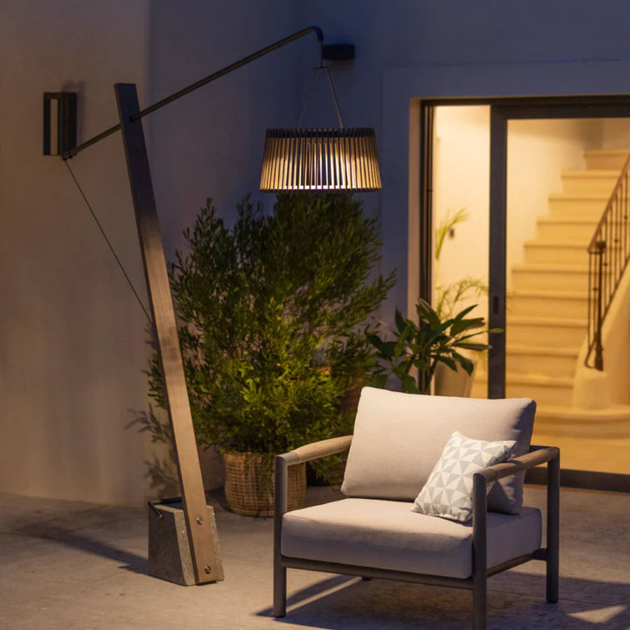 Modern outdoor chair with a solar floor lamp and plants in a garden setting by Les Jardins available at Spacio retail stores in Mumbia & Kolkata. 