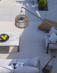 Outdoor patio on a sunny day with gray sofa, coffee table, and outdoor floor lamp by Les Jardins available at Spacio retail stores in Mumbia & Kolkata. 